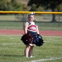 Young Titans cheerleader with pom-poms on the field