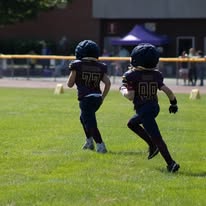 Two young Titans football players running together