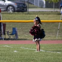 Young Titans cheerleader with pom-poms on the field