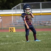 Young Titans football player standing ready on the field