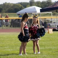 Two young Titans cheerleaders with pom-poms on the field