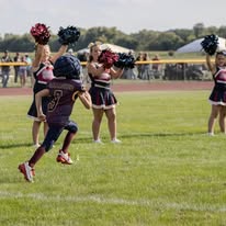 Young Titans football player running past the cheerleaders