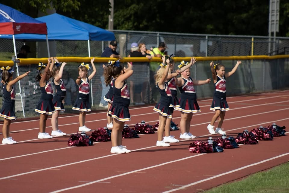 Titans cheer squad cheering with arms raised on the track
