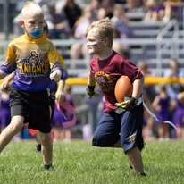 Two young flag football players running during a game