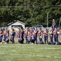 Titans football players kneeling on the sideline before kickoff