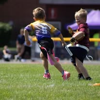 Young flag football players running during a game