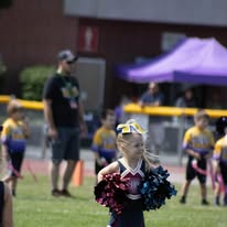 Young Titans cheerleader with pom-poms on the field