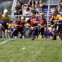 Group of young Titans players running with footballs