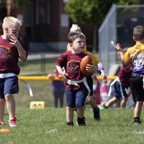 Young flag football player holding the ball on the field