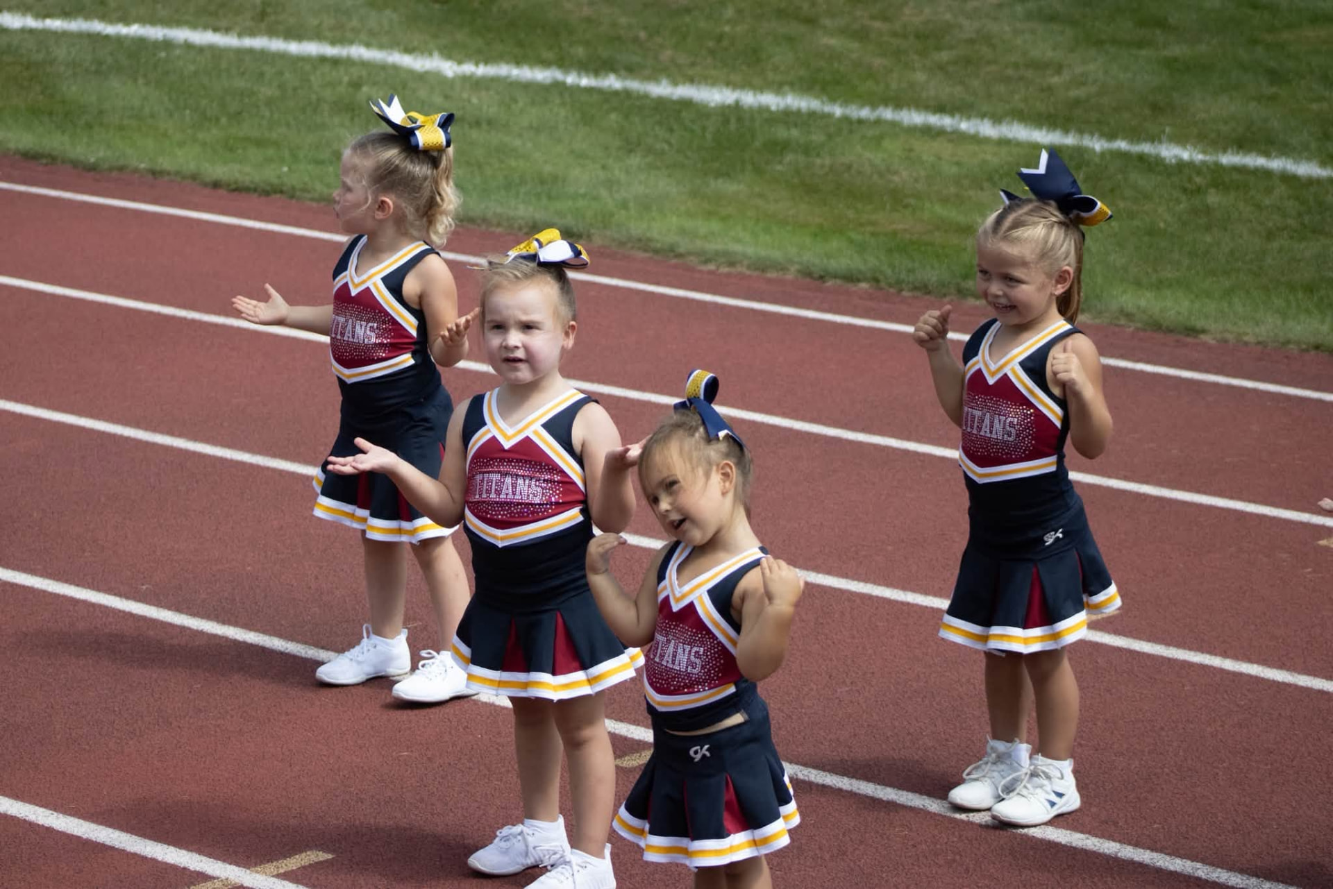 Littlest Titans cheerleaders cheering on the track