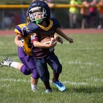 Two young Titans football players during a tackle