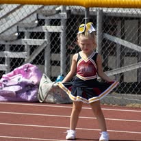 Young Titans cheerleader with pom-poms on the track