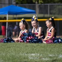 Titans cheerleaders sitting on the field with pom-poms