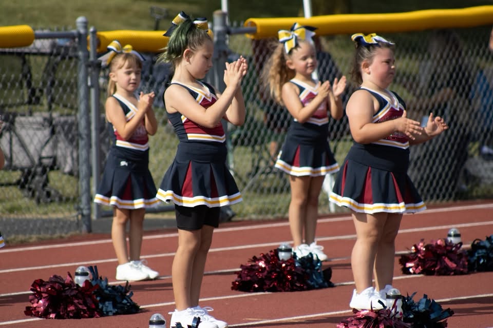 Young Titans cheerleaders clapping on the track