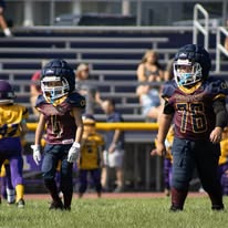 Two young Titans football players standing on the field