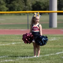 Young Titans cheerleader with pom-poms on the field
