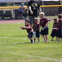 Young flag football players running down the field