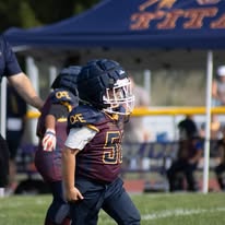 Young Titans football player carrying the ball