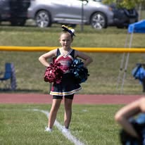 Young Titans cheerleader with pom-poms on the field