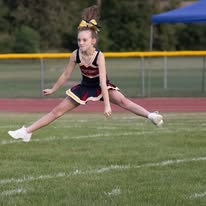 Titans cheerleader leaping into a jump on the field