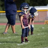 Young Titans football player standing ready on the field