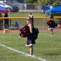 Young Titans cheerleader with pom-poms on the field