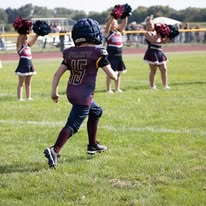 Titans flag football player running past cheerleaders