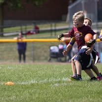Young Titans flag football player carrying the ball