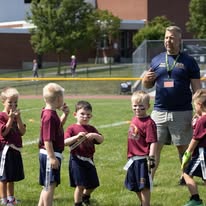 Young flag football players with their coach on the field