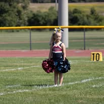 Young Titans cheerleader with pom-poms on the field