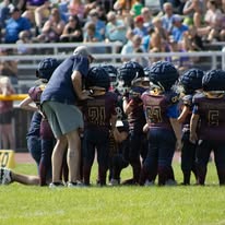 Titans coach talking with players in a huddle
