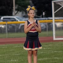 Titans cheerleader with yellow bow standing on the field